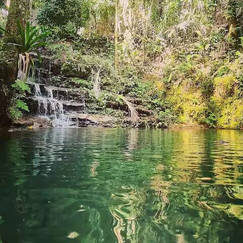 Água verde-esmeralda do poço da cachoeira