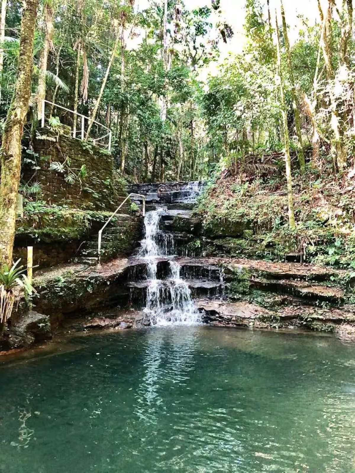 A queda d’água vista da margem do poço