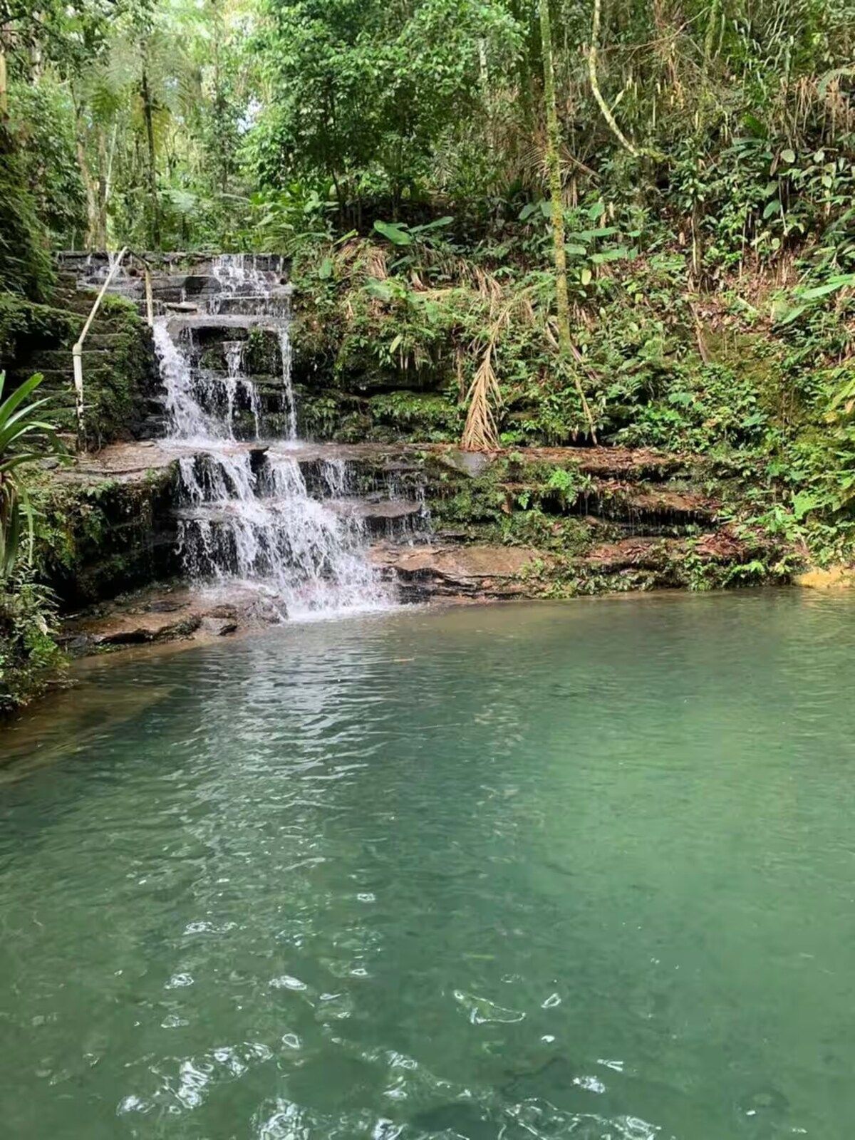 Cachoeira caindo em degraus de pedra sobre o poço