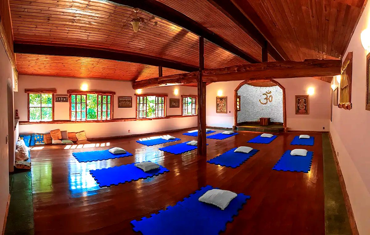 Salão Radha Yoga com o altar ao fundo e os tapetes postos